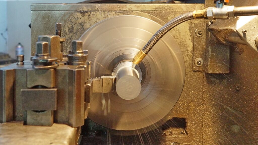 Tornio di precisione al lavoro su un componente metallico in officina meccanica
