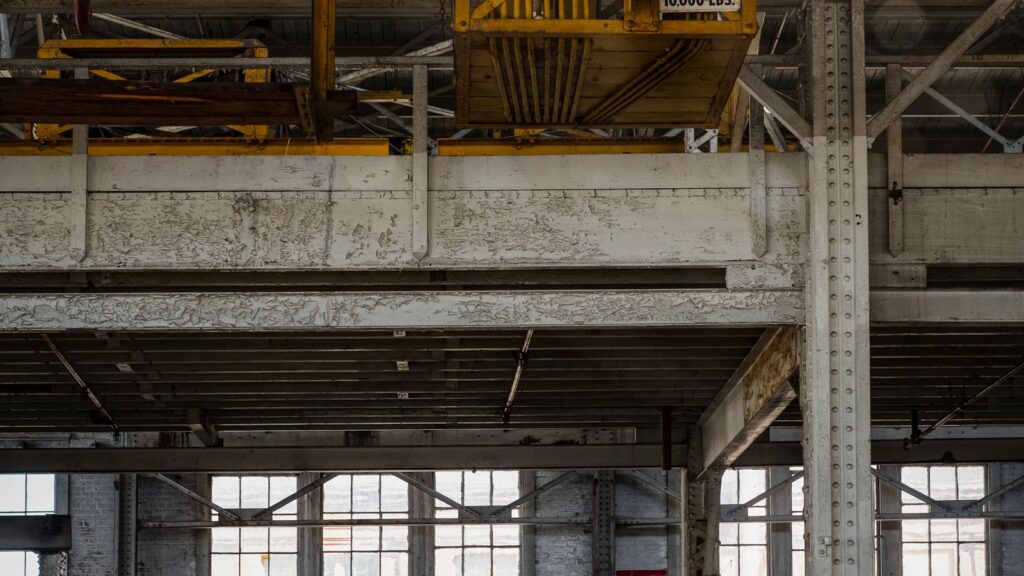 Grande capannone industriale vuoto con carroponte e finestre alte