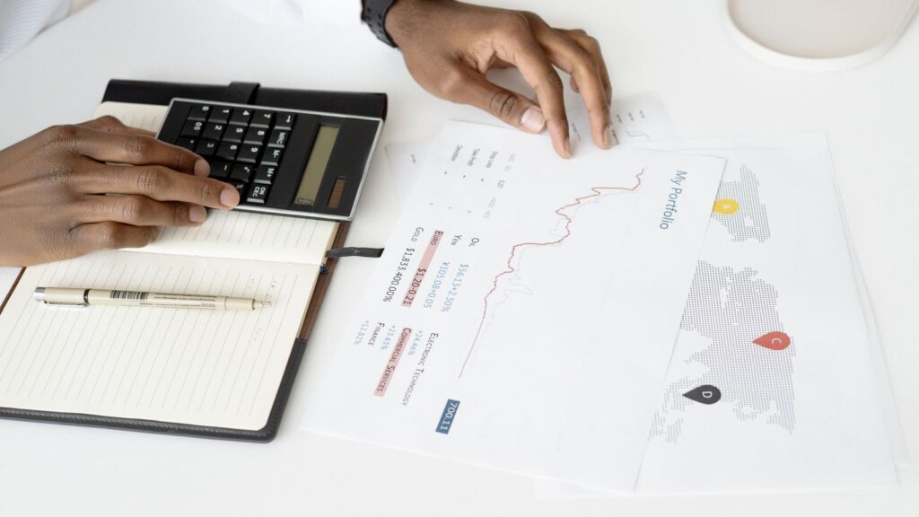 Documenti finanziari e calcolatrice su una scrivania, vista dall'alto